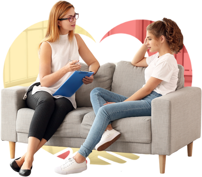 A girl sitting with a therapist while the therapist takes notes and speaks to the girl.