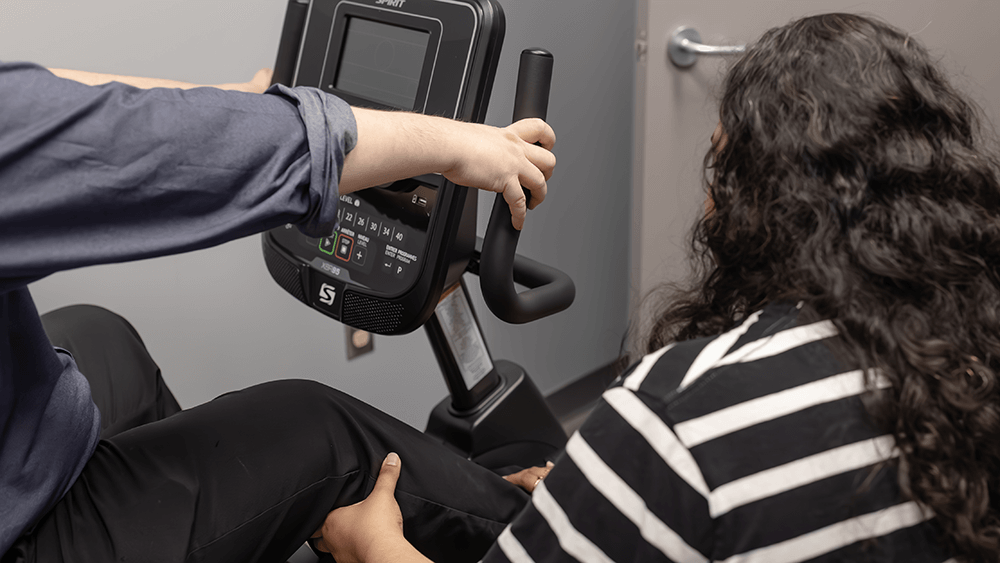 Bansari Patel practicing Physiotherapy on a seated patient.