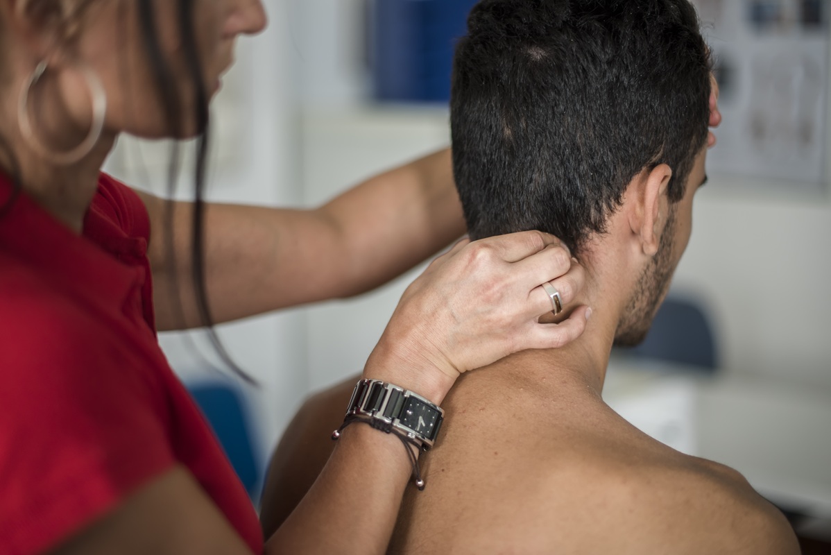 Man receiving neck massage from healthcare professional